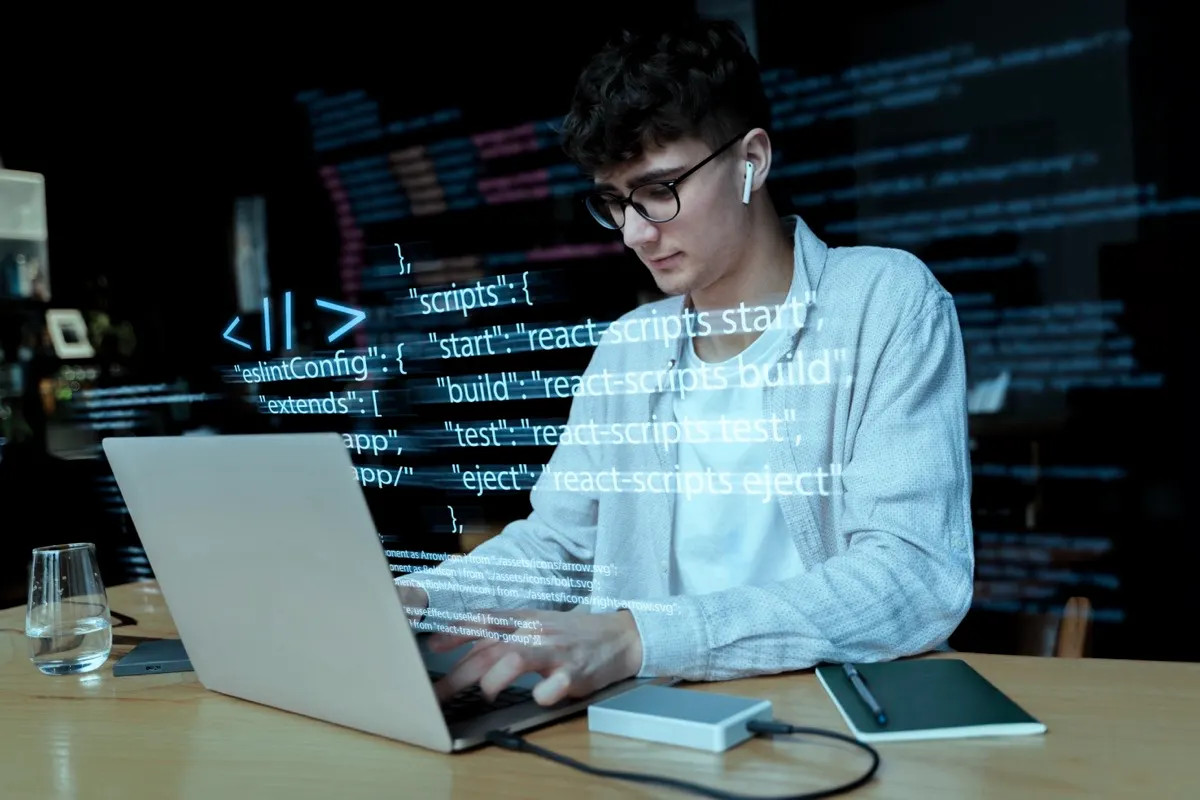 Desarrollador trabajando en una computadora portátil con código en pantalla